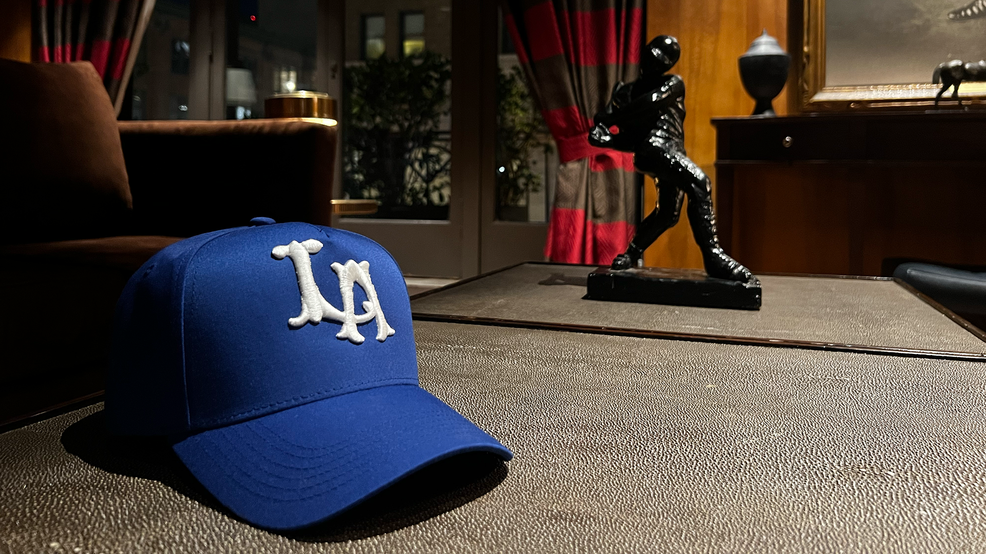Close up photo of LA hat with baseball statue in back